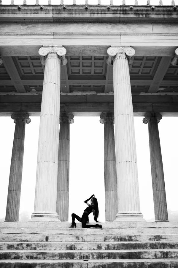 Dancer posed beneath towering marble columns