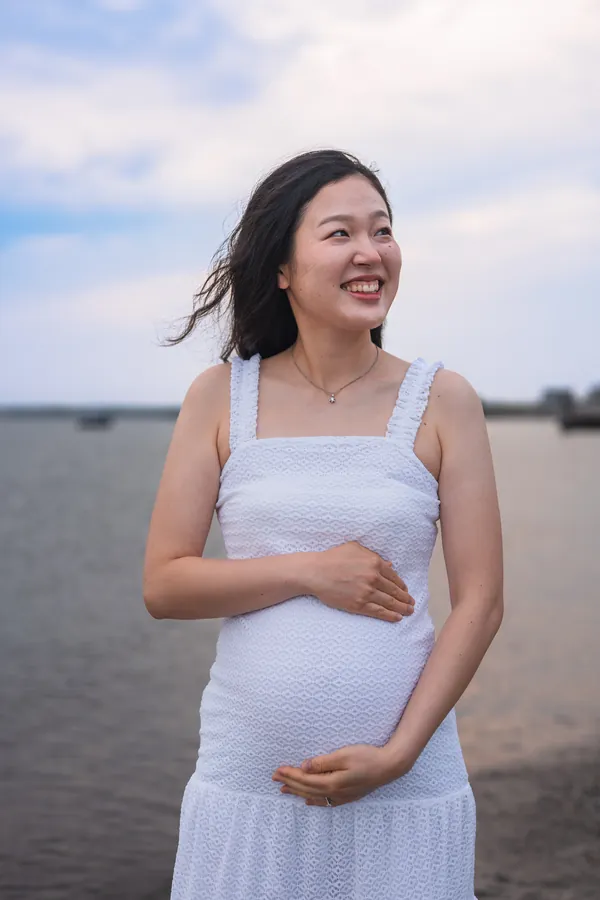 Expectant mother smiling on the beach